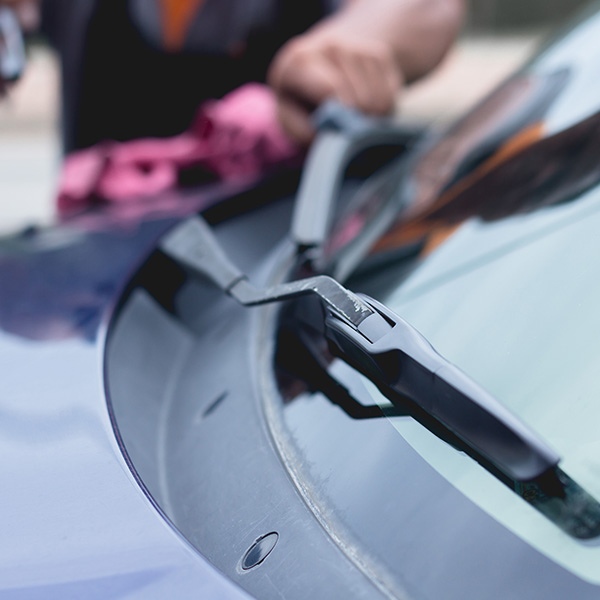 Mechanic replacing old windshield wipers on car in the New Port Richey and Port Richey, FL area