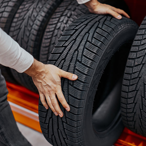 Customer holding car tire in auto shop
