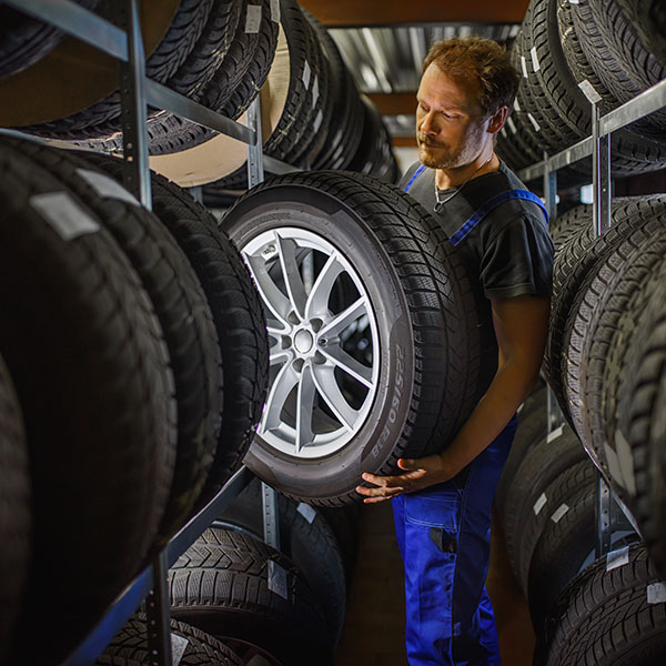 Mechanic choosing tire from the storage rack