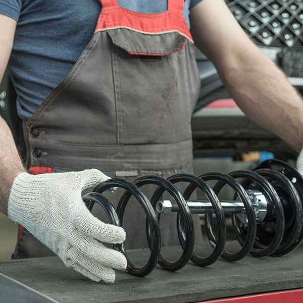 Mechanic holding a new car suspension part in his hands in the New Port Richey and Port Richey, FL area