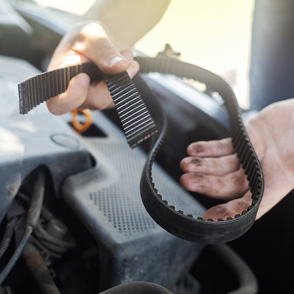 Mechanic holding a broken front belt in his hands
