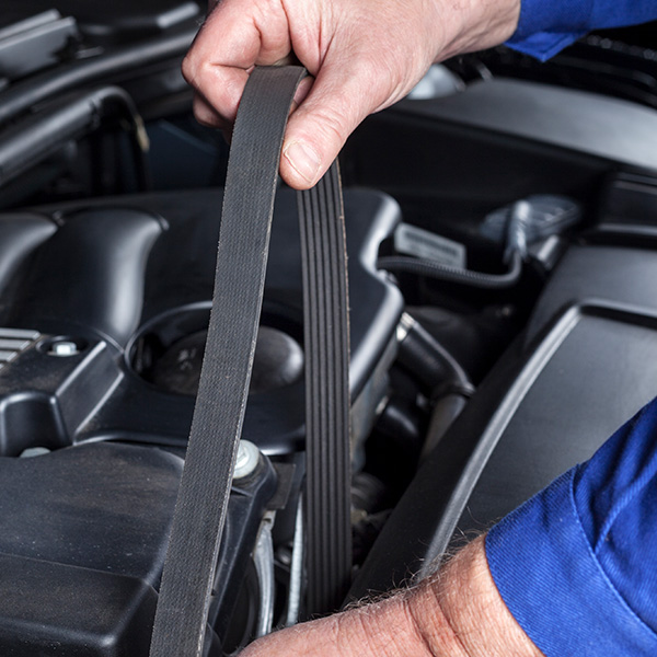 Mechanic changing the transmission belt of a car engine