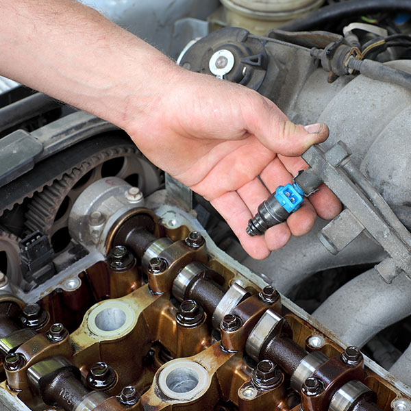 Mechanic cleaning car's fuel injector