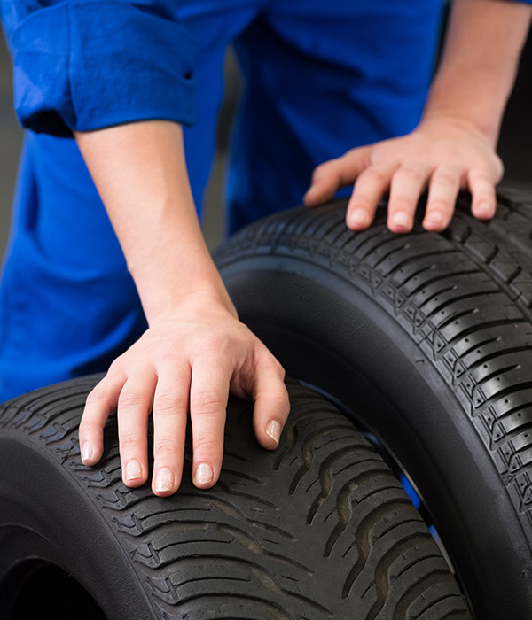 Mechanic holding car tires at garage