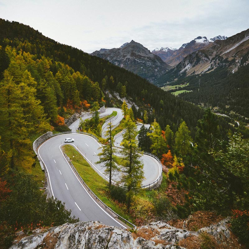car driving down winding mountain road